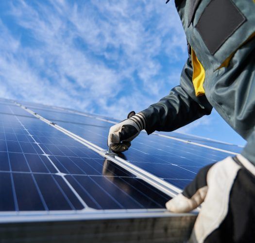 Male worker repairing photovoltaic solar panel.
